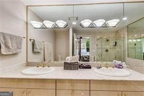 full bathroom with a stall shower, a sink, and double vanity