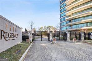 view of road featuring curbs, a gated entry, and a gate