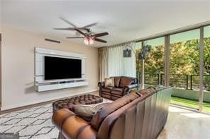 living room with expansive windows, visible vents, ceiling fan, and baseboards