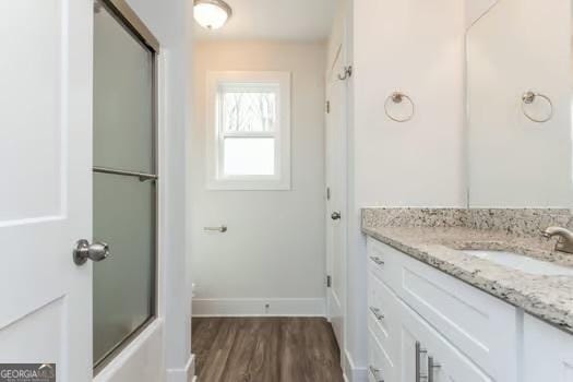 bathroom featuring wood finished floors, vanity, and baseboards