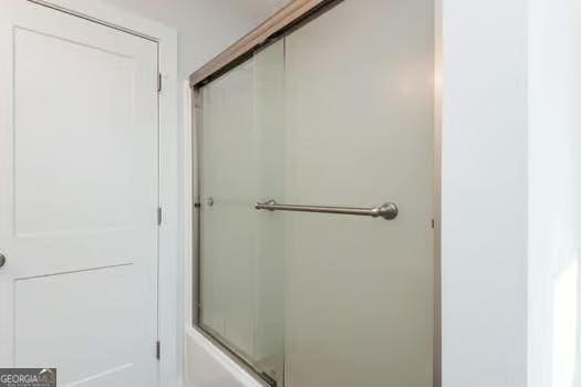 bathroom with a shower with door