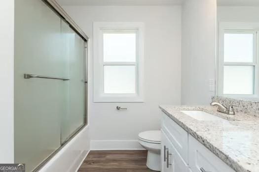 bathroom with plenty of natural light, vanity, and toilet