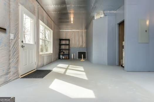 unfurnished living room with concrete floors and electric panel