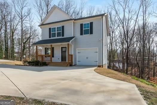 view of front of home with an attached garage, driveway, and a porch