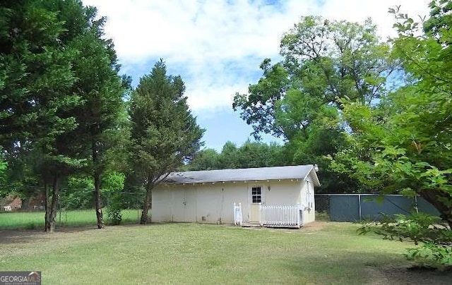 view of outdoor structure featuring an outbuilding and fence