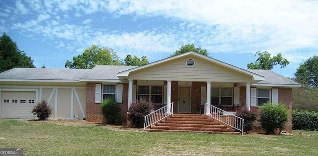 view of front of home with an attached garage, covered porch, a front lawn, and brick siding