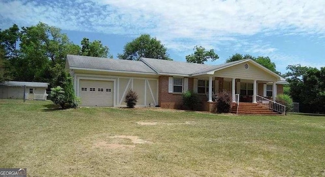 ranch-style home with covered porch, a garage, brick siding, driveway, and a front lawn