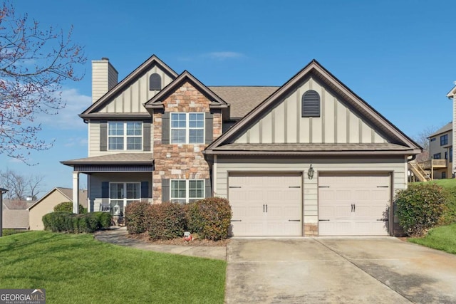 view of front facade featuring driveway, a garage, stone siding, board and batten siding, and a front yard