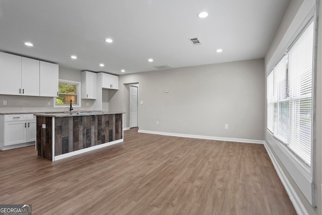 kitchen featuring baseboards, light wood-style flooring, and white cabinets