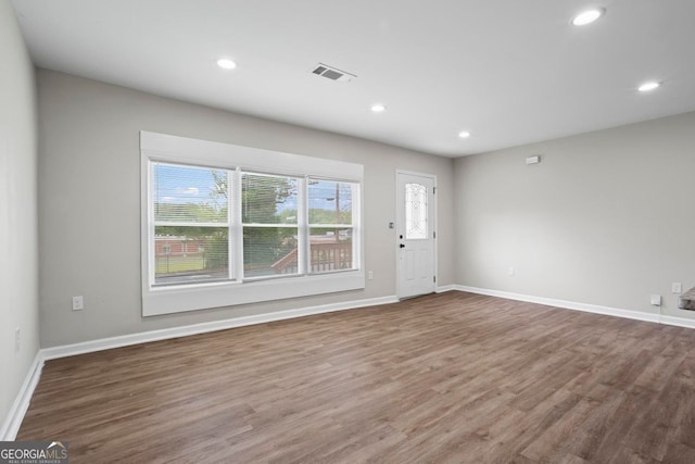 unfurnished living room with baseboards, recessed lighting, wood finished floors, and visible vents