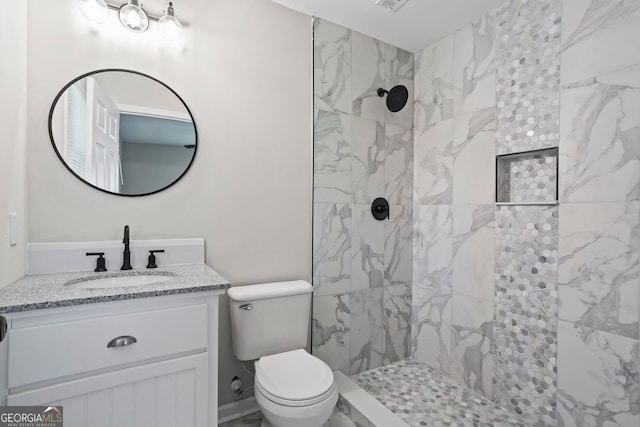 full bath with vanity, toilet, and tiled shower