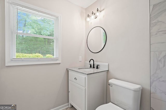 bathroom featuring vanity, a healthy amount of sunlight, and toilet