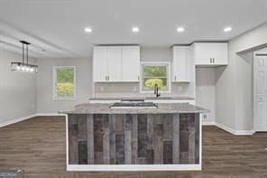 kitchen featuring a kitchen island, white cabinetry, baseboards, and dark wood-style floors