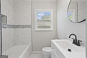 bathroom with toilet, baseboards, and vanity