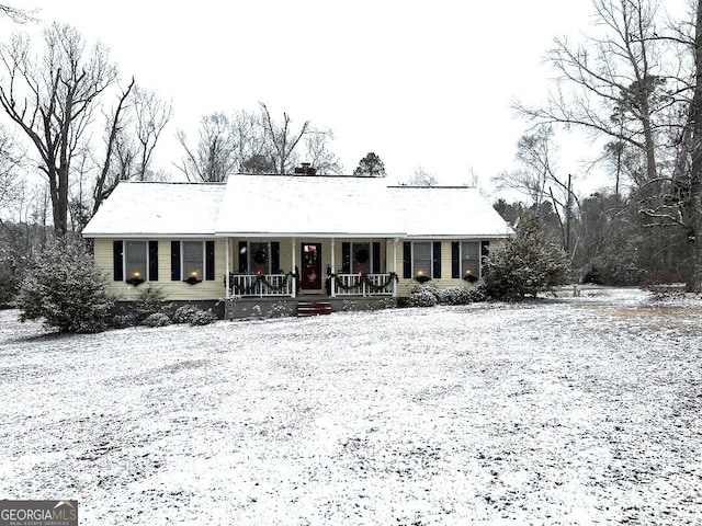 ranch-style home featuring covered porch and a chimney