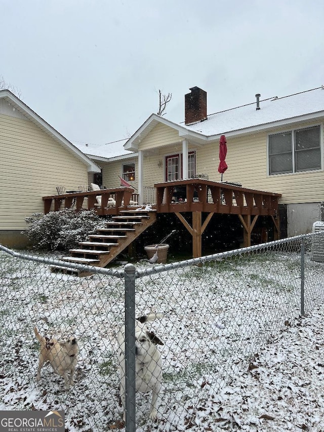 back of house featuring a chimney, fence, and a deck