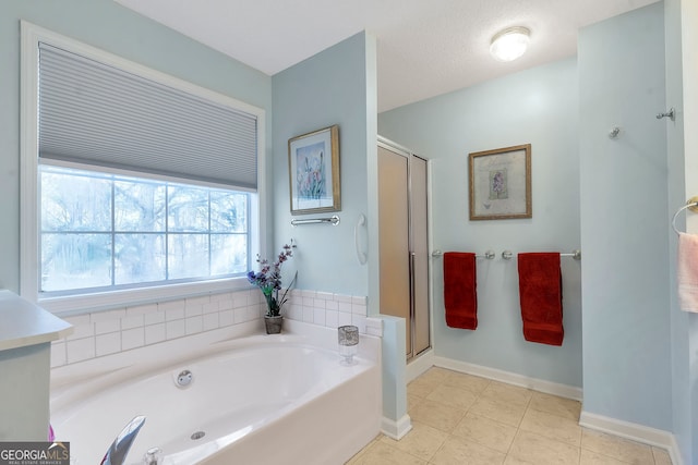 bathroom featuring a garden tub, tile patterned floors, baseboards, and a stall shower