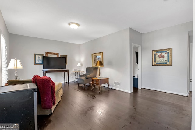 living area featuring wood finished floors, visible vents, and baseboards