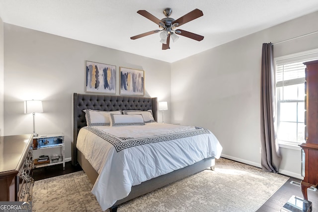 bedroom with visible vents, baseboards, ceiling fan, and wood finished floors