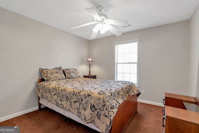 bedroom featuring a ceiling fan, visible vents, dark carpet, and baseboards