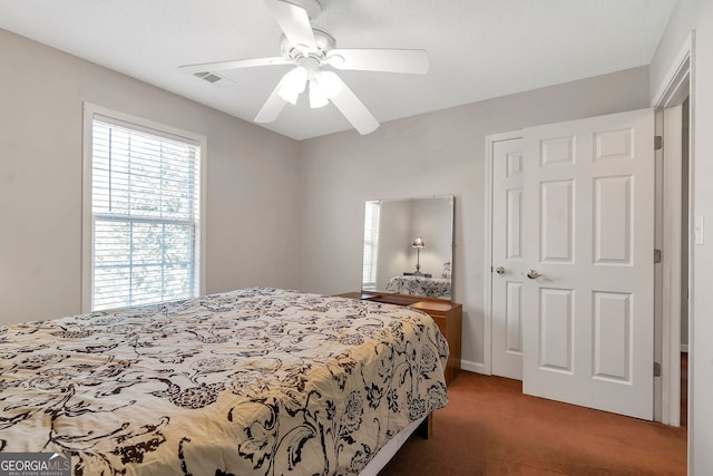 bedroom with carpet, visible vents, and ceiling fan