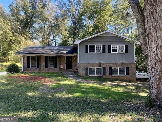 split level home with brick siding and a front yard