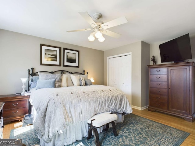 bedroom with baseboards, a closet, a ceiling fan, and light wood-style floors