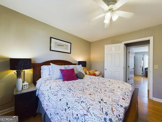 bedroom featuring ceiling fan, baseboards, and wood finished floors