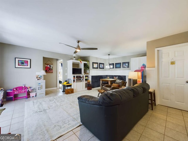 living area with light tile patterned flooring and a ceiling fan