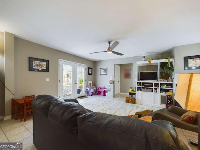 living room with light tile patterned floors, ceiling fan, french doors, and baseboards