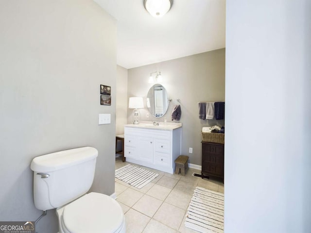 bathroom featuring tile patterned flooring, baseboards, vanity, and toilet