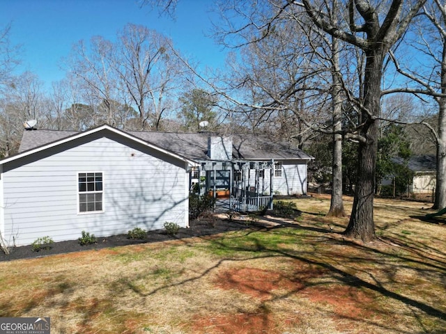 view of side of home with a yard