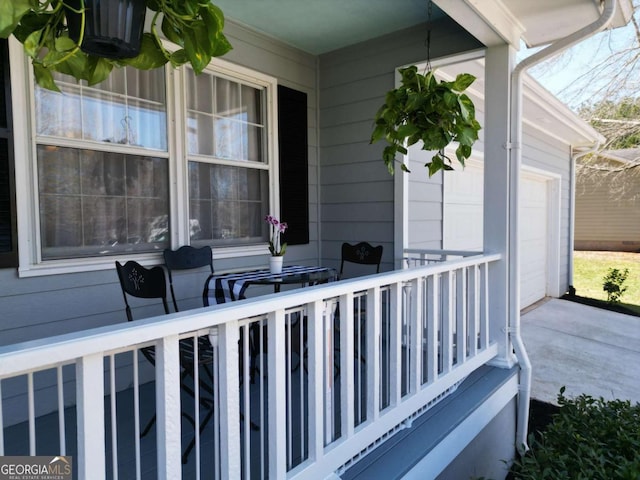 view of patio / terrace featuring an attached garage and covered porch