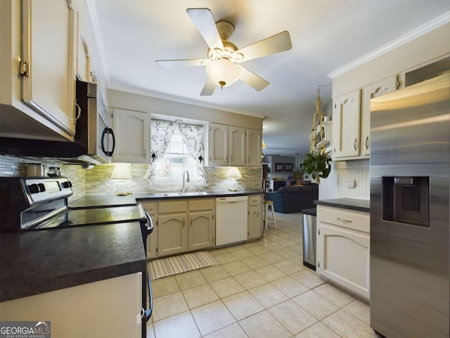 kitchen featuring dark countertops, ceiling fan, a sink, stainless steel appliances, and backsplash