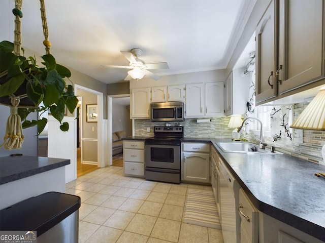kitchen with backsplash, stainless steel appliances, light tile patterned floors, and a sink