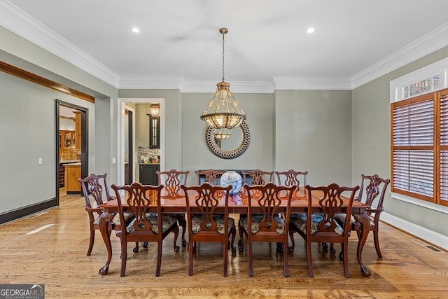 dining area featuring visible vents, baseboards, light wood-style flooring, and crown molding