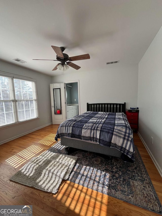 bedroom with visible vents, baseboards, and wood finished floors