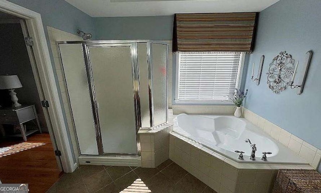 bathroom with a stall shower, tile patterned flooring, and a garden tub