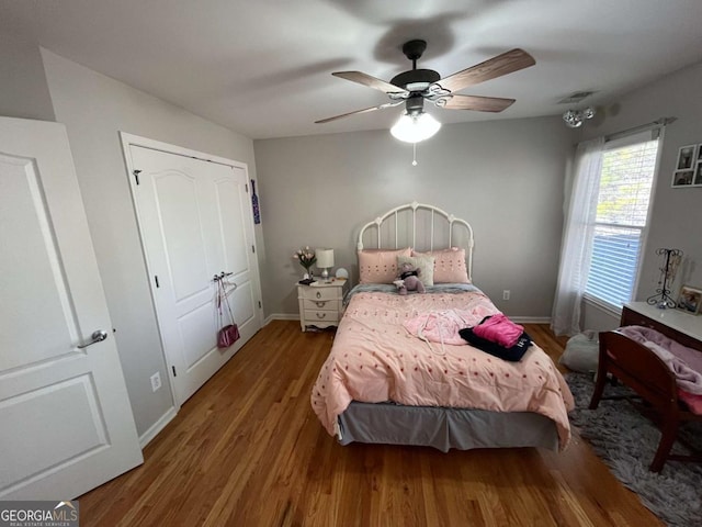 bedroom with visible vents, baseboards, ceiling fan, and wood finished floors