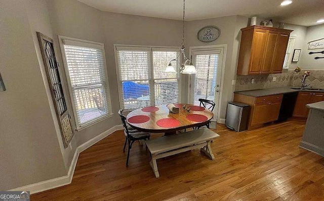 dining area with light wood-style floors, baseboards, and an inviting chandelier