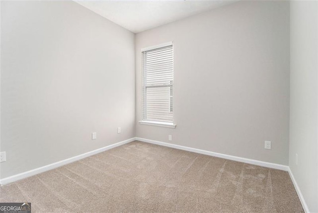 carpeted spare room featuring baseboards