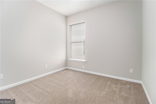 carpeted empty room featuring baseboards