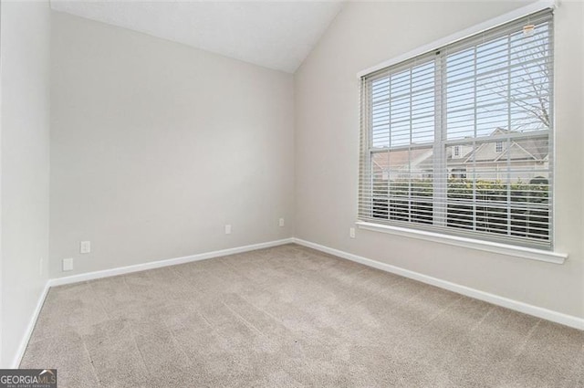 unfurnished room with vaulted ceiling, carpet, and baseboards