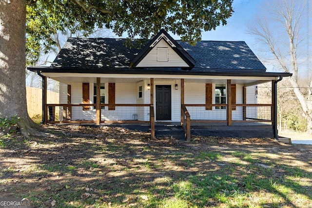 farmhouse with covered porch and a shingled roof