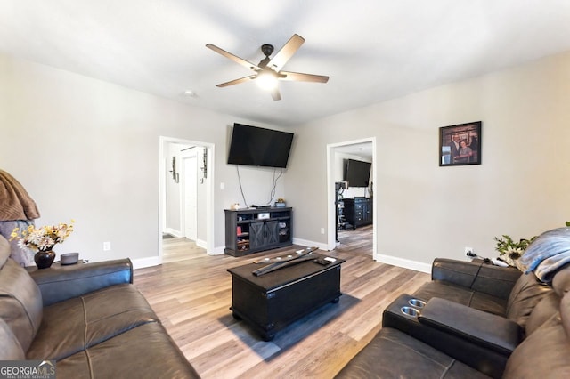 living area with ceiling fan, light wood-type flooring, and baseboards