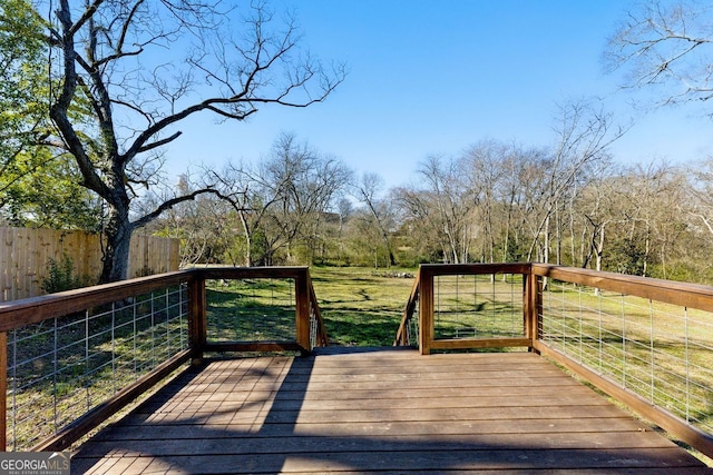 wooden deck with a yard and fence