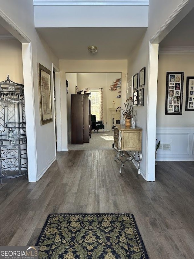 hall featuring ornamental molding, wood finished floors, and visible vents