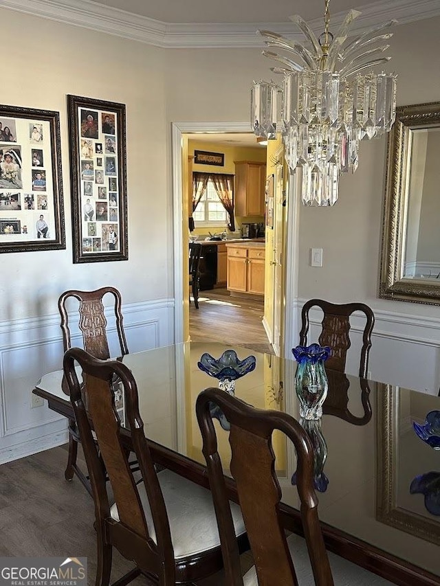 dining room with a chandelier, ornamental molding, and wood finished floors