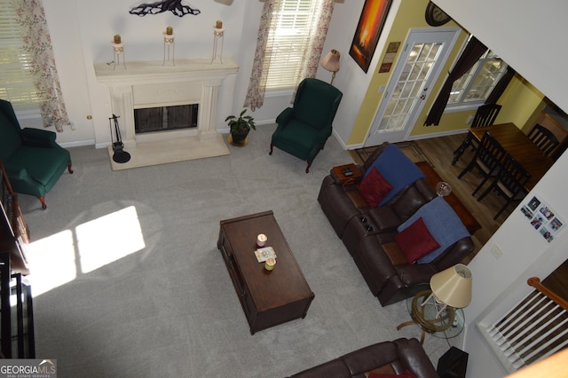 living area featuring carpet, baseboards, and a high end fireplace