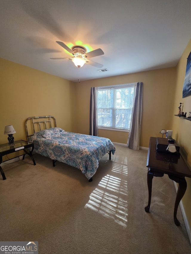 carpeted bedroom featuring baseboards, visible vents, and a ceiling fan